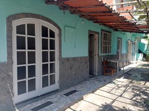 ein Haus mit einer weißen Tür und einem Tisch im Freien in der Unterkunft Família Souza in Cabo Frio