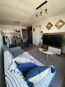 a living room with a couch and a tv at Precioso departamento amueblado 2 habitaciones + 2 baños in Los Ángeles