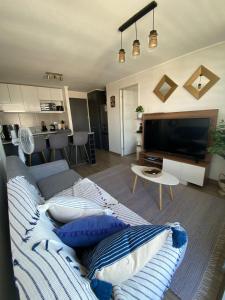 a living room with a couch and a flat screen tv at Precioso departamento amueblado 2 habitaciones + 2 baños in Los Ángeles
