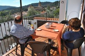 Ein Mann und eine Frau, die an einem Tisch auf einem Balkon sitzen in der Unterkunft Casa Rural Aya I in Linares de la Sierra