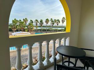 einen Balkon mit Blick auf den Strand und die Palmen in der Unterkunft MERAKII SEAVIEW ESCAPE CURACAO in Willemstad