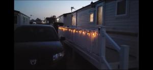 a car parked next to a train with lights on it at Chapel's cozy caravan in Chapel Saint Leonards