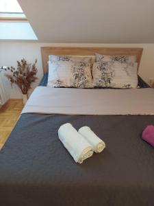 a bedroom with a bed with two towels on it at Apartman Panorama in Požarevac