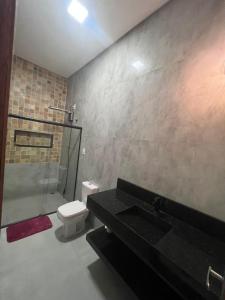 ein Bad mit einer Dusche, einem WC und einem Waschbecken in der Unterkunft Casa fernandes in Piranhas