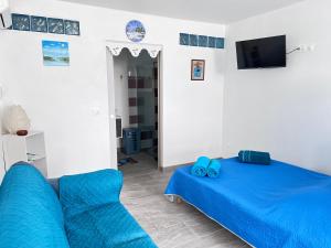 un soggiorno con letto blu e divano di Votre Cocon Océan : Studio bien aménagé à louer a Sainte-Luce