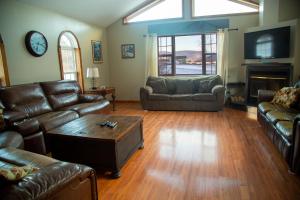 a living room with leather couches and a tv at The Maples - Hot tub! Amazing views, pets welcomed in Ellicottville