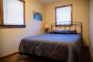 a bedroom with a bed and two windows at The Maples - Hot tub! Amazing views, pets welcomed in Ellicottville