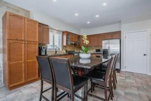 a kitchen with a table and chairs and a refrigerator at Comfortable Modern Room near YKF Airport III in Kitchener