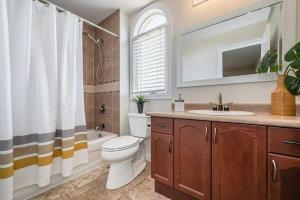 a bathroom with a toilet and a sink and a mirror at Comfortable Modern Room near YKF Airport III in Kitchener