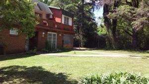 a red brick house with a grass yard at Quinta Don Diego in Piñero