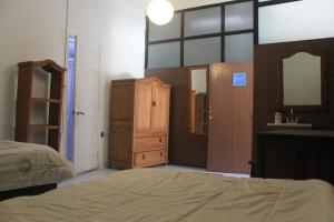 1 dormitorio con cama, tocador y espejo en Posada Santa, en San Cristóbal de Las Casas