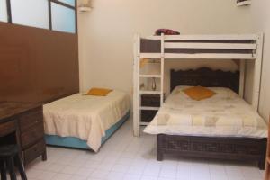 聖克里斯托瓦爾－德拉斯卡薩斯的住宿－桑塔賓館，一间卧室配有两张双层床和一张书桌
