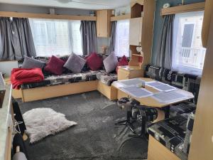 a living room with a couch and a table at Chapel's cozy caravan in Chapel Saint Leonards