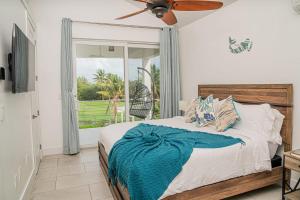 Villas with Private Pool 5 min to Grace Bay beach في Long Bay Hills: غرفة نوم مع سرير ومروحة سقف