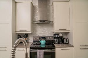 a kitchen with white cabinets and a stove top oven at Villas with Private Pool 5 min to Grace Bay beach in Long Bay Hills