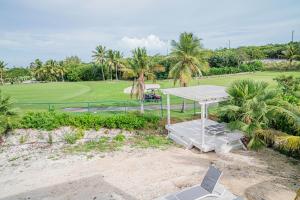 uma vista sobre um campo de golfe com uma mesa e cadeiras em Villas with Private Pool 5 min to Grace Bay beach em Long Bay Hills