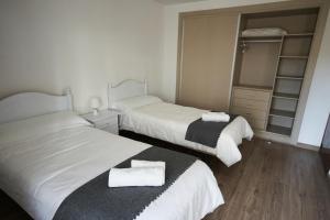 2 Betten in einem Hotelzimmer mit Handtüchern darauf in der Unterkunft Céntrico apartamento Playa de San Juan Alicante in Alicante