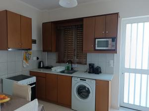 a kitchen with a washing machine and a microwave at G.S. Studio 1 in Mastihari