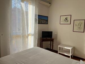 ボローニャにあるCasa Francia Alidosiのベッドルーム1室(ベッド1台付)、窓(テレビ付)