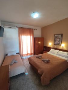 a hotel room with two beds and a window at Aleka apartment 4 in Agios Georgios