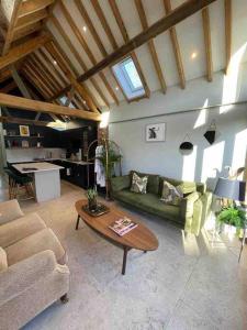 a living room with a green couch and a table at Luxury private FARM BARN, Airport, NEC 