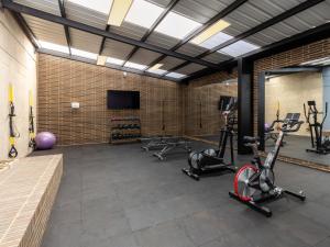 Un gimnasio con varias bicicletas estáticas y un televisor de pantalla plana. en Beliving by Wynwood House, en Bogotá
