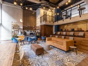 a lobby with a couch and chairs and a bar at Life by Wynwood House in Bogotá
