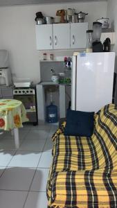 una cucina con divano e frigorifero di Kitinete Aconchegante a Porto De Galinhas