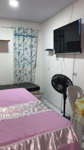 1 dormitorio con 1 cama y TV de pantalla plana en Kitinete Aconchegante, en Porto de Galinhas