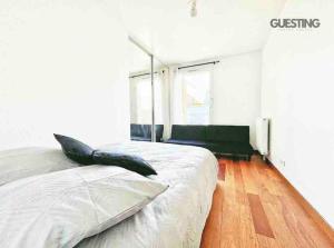 um quarto com uma cama grande e piso em madeira em Top Apartment Île St-Denis aux Portes de Paris em Saint-Ouen
