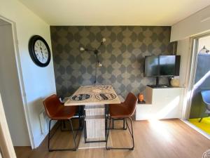 Habitación con mesa, sillas y TV. en Appartement cosy rénové 4 personnes en centre ville Wifi inclus, en Quiberon