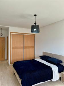 ein Schlafzimmer mit einem Bett mit einer blauen Decke in der Unterkunft Lovely family apartment in Tetouan in Tétouan