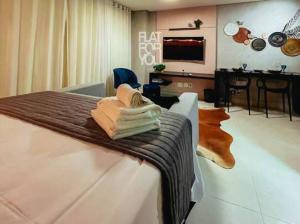 a hotel room with a bed with a table and a television at #2005# STUDIO BROOKFIELD TOWERS COM CHURRASQUEIRA in Goiânia