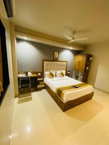 a bedroom with a large bed and a desk at New Hotel Amber International Near International Airport T2 in Mumbai