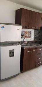 a kitchen with a white refrigerator and a sink at Apto en centro de floridablanca in Floridablanca