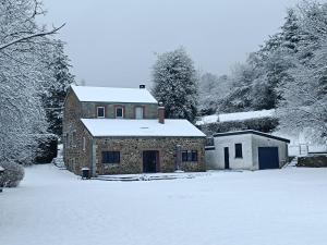 una casa de piedra con nieve en el suelo en un patio en le Lombry, en Aywaille