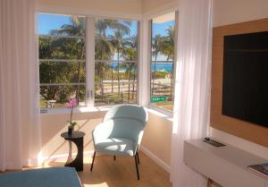 a living room with a chair and a large window at Avalon Hotel in Miami Beach