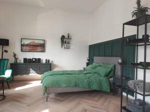 - une chambre avec un lit et une couverture verte dans l'établissement Stilvolles Appartment in Hagen, à Hagen