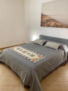 ein Bett mit zwei Kissen auf einem Zimmer in der Unterkunft Casa Marconi duplex avec terrasse in Aragona