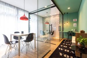 a dining room with glass walls and a table and chairs at Setin Downtown Genebra by Viva - Apartamentos completos na Bela Vista com piscina in São Paulo