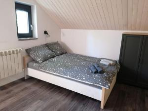 a bed in a room with two shoes on it at Domek Zielony Widok - noclegi Bieszczady in Lesko