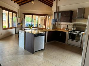 a large kitchen with a sink and a stove at Casa vacacional in Loja