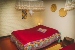 a bedroom with a red bed in a room at Room in Guest room - Isange Paradise Resort in Ruhengeri