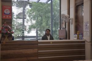 Ein Mann, der an einem Tresen in einem Restaurant sitzt. in der Unterkunft Prashant Hotel Indore in Indore