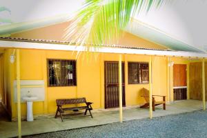 een geel huis met een bank en een wastafel bij Dominga's Eco-Yellow Hideaway in Puerto Viejo
