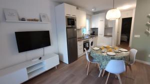 a kitchen with a table with chairs and a television at Acogedor apt en casco historico in Marbella