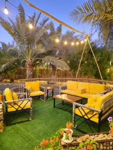 a patio with yellow couches and a swing at Hatta Farm caravan in Hatta