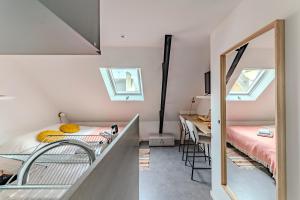 Zimmer mit einem Bett, einem Waschbecken und einem Spiegel in der Unterkunft Charmant studio à deux pas de la gare - Le Nichoir in Rennes