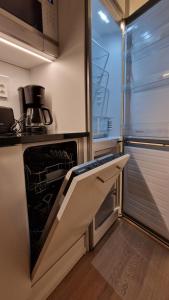 a kitchen with an open oven with a window at Silent apartment with balcony in Turku