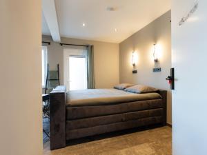a bedroom with a bed and a desk at Luxe kamer B&B Gezond aan Zee, met jacuzzi en stoomsauna, de wellnestuin buiten is te huur voor privé gebruik tegen meerprijs in Ouddorp